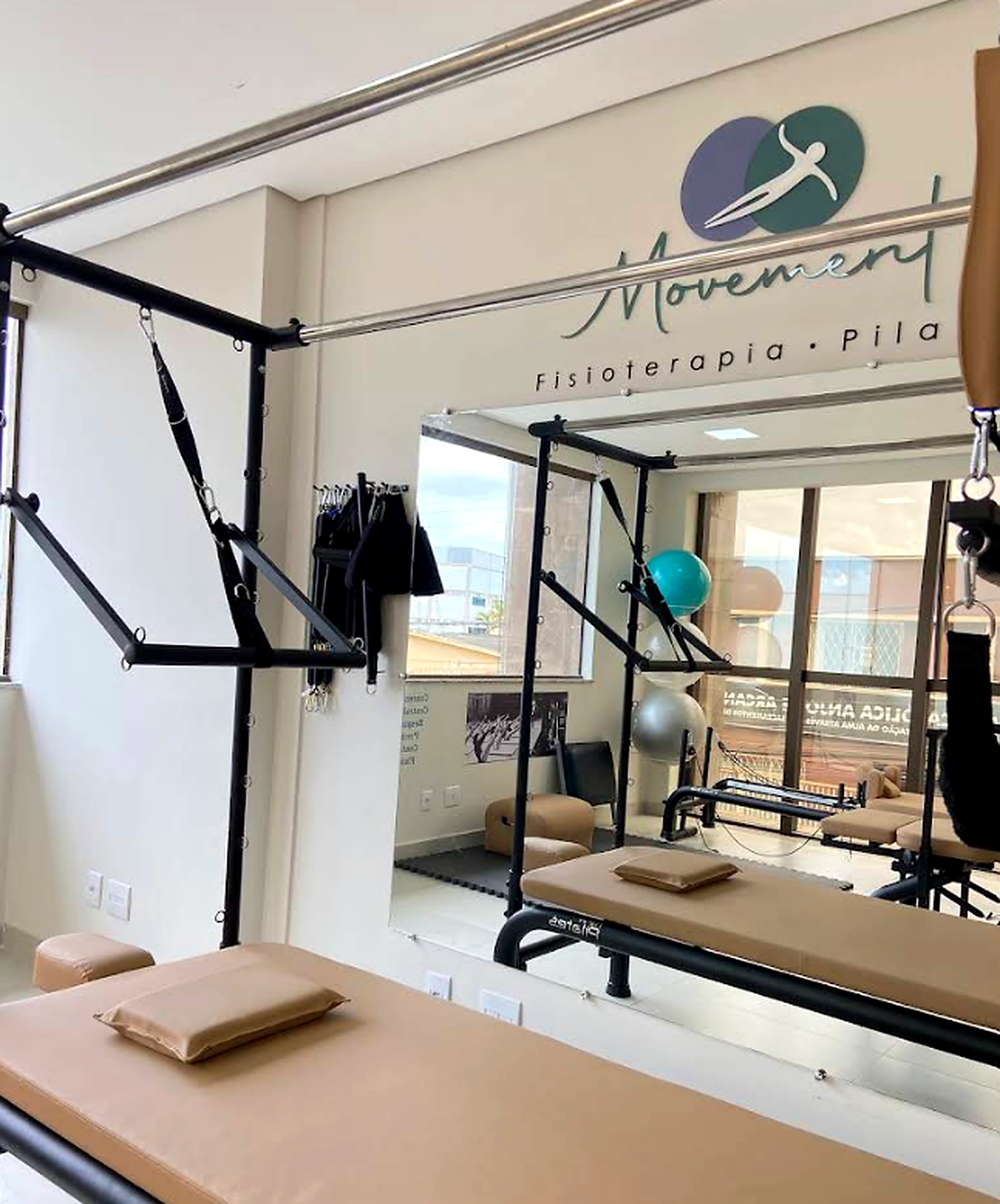 Sala de Pilates da Clínica Movement com logo na parede